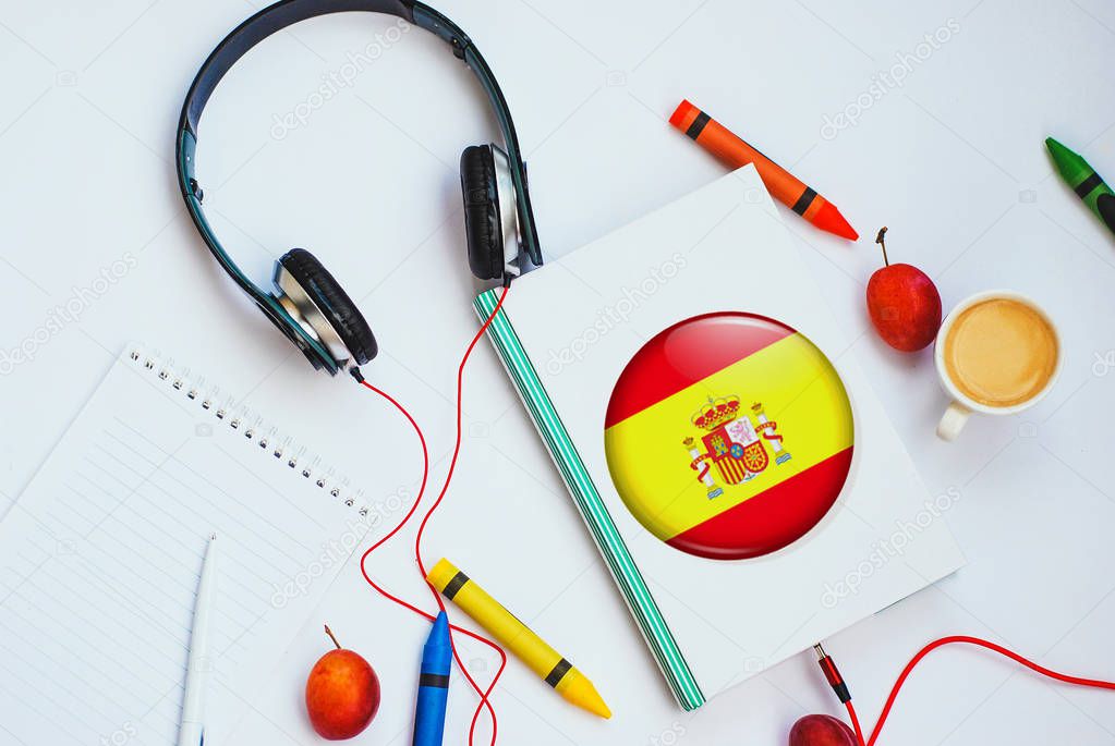 the book with spanish flag and headphones. concept of spanish learning through audio courses
