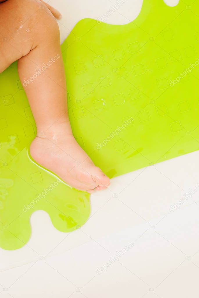 Baby feet on anti slip rubber mat for bathroom