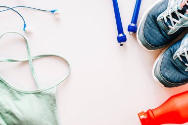 Düz spor sutyen, ip atlama, spor ayakkabı ve şişe beyaz arka plan, çalışma dışarı ve sağlıklı kavramı, üstten görünüm üzerinde yatıyordu
