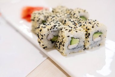 Karidesli suşi, avokado, krem peynir ve susamlı. Suşi menüsü. Japon yemeği..