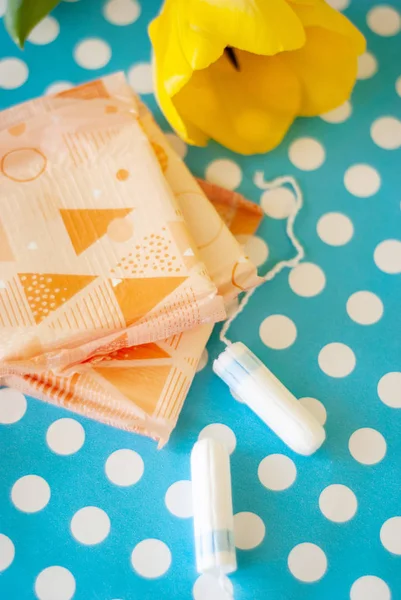 Adet tampon ve yastıkları mavi bir arka plan üzerinde. Adet döngüsü. Hijyen ve koruma.