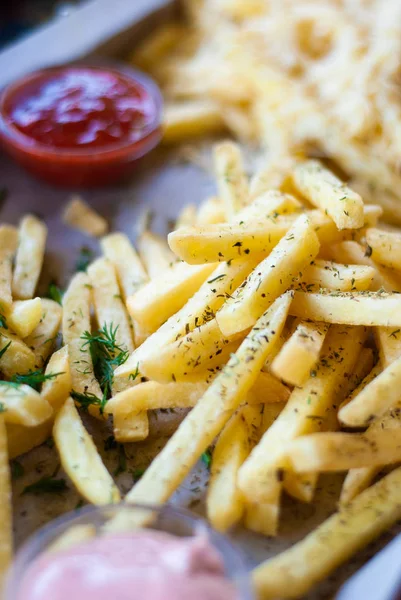 French fries with spicy seasoning in wooden plate on wooden broad. — Stock Photo, Image