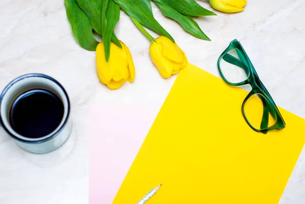 Tulipe jaune, café, verres verts et papier coloré sur fond de marbre — Photo