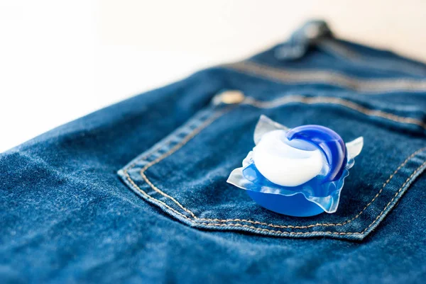 Kapselkapsel für Wäsche und Waschmittel auf Jeans. — Stockfoto