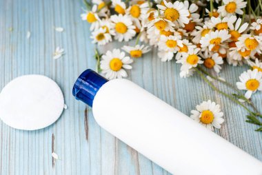 Bitkisel papatya çiçekleri olan beyaz şişe kabı..