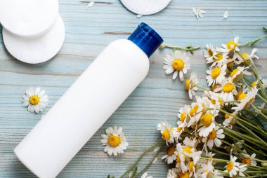 Bitkisel papatya çiçekleri olan beyaz şişe kabı..