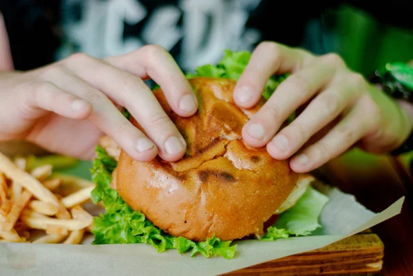 Homme dans un restaurant qui mange un hamburger, il a faim et mange bien. focus sélectif — Photo