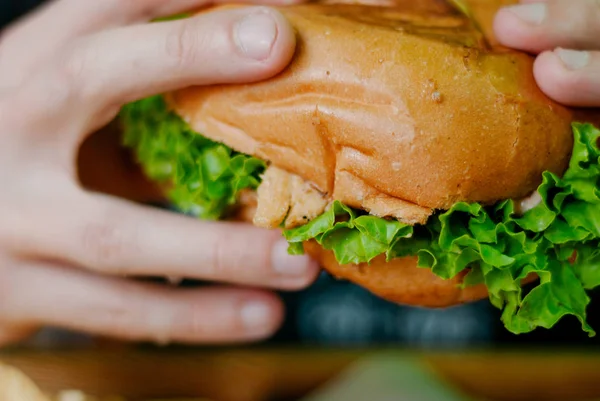 Homme dans un restaurant qui mange un hamburger, il a faim et mange bien. focus sélectif — Photo