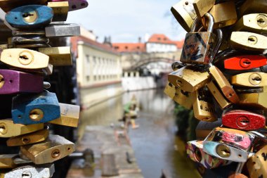 Bir korkuluk arka planda bir kanal üzerinde turistler tarafından izin birçok renkli aşk kilitleri yakın çekim.
