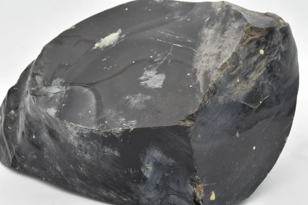 A big piece of black Obsidian, a natural volcanic glass with white background