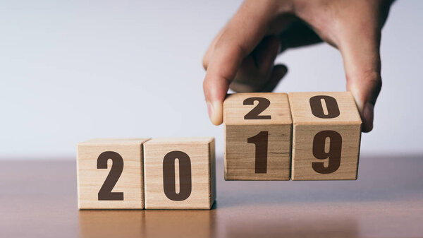 New year 2019 change to 2020 concept, hand change wooden cubes