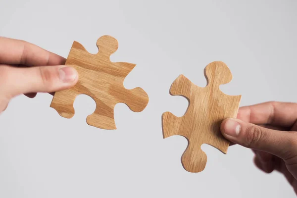 İki el çift ahşap bağlanmaya çalışıyor parça puzzle. Dernek ve bağlantısı, iş stratejisi kavramı.