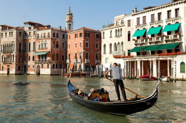 Venedik, İtalya - 26 Mayıs 2010: Turistler Venedik 'in sakin kanallarında güzel binalarla çevrili bir gondolla süzülüyorlar.