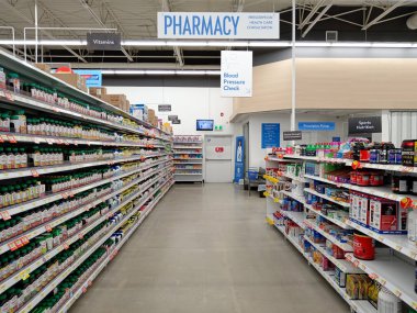 Penticton, Kanada - 19 Nisan 2025: Walmart 'ın eczane bölümünde raflar sağlık ürünleri ve ilaçlarla dolu.. 