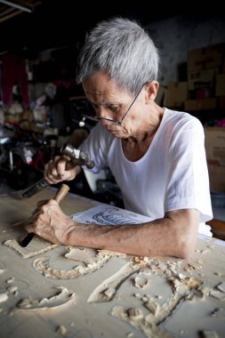 Penang, Malezya - 25 Eylül 2010: Georgetown 'da geleneksel Çin tabela oymacısı. 60 'lı yaşlarının sonundaki Kok Ah Wah' ın Malezya 'nın son geleneksel tabelacısı olduğuna inanılıyor..