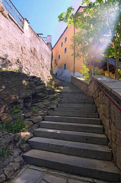 Ancient narrow stairs in Cesky Krumlov at sunny day. The historical center of the city in 1992 is listed as a UNESCO World Heritage Site. Czech Republic.