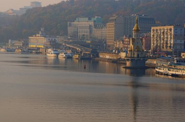 Kiev, Ukrayna-Ekim 20, 2018: Sonbahar sabah cityscape şehir set, Dnipro Nehri nehir limanı yakınında of. Aziz Nikolaos Kilisesi'nin Wonderworker suya yansıyan.