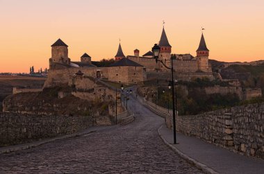Sabah gündoğumu sırasında ortaçağ Kamianets-Podilskyi Kalesi panoraması. Sonbahar manzara. Meşhur turistik mekanlar ve romantik seyahat hedef. Kamianets-Podilskyi, Khmelnitsky region, Ukrayna.