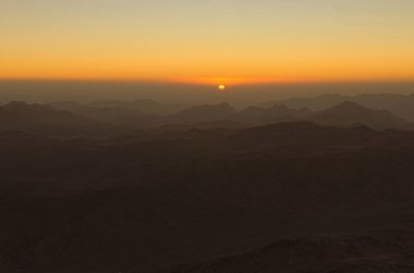 Doğal gündoğumu dağlarda. Güneşin bulut çıkar. Mount Sinai (Mount Horeb, Gabal Musa, Moses Mount) görünümden. Sina Yarımadası Mısır.