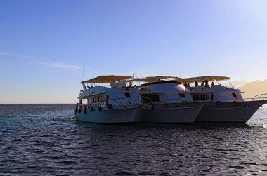 Dahab, Mısır-Ocak 06, 2019: üç yolcu gemilerine yakınındaki sakin Kızıldeniz kayalıkta demirlemiş. Turistler dalış veya dalış scuba diving temiz su ile geçerlidir. Yaz tatil ve Turizm kavramı.
