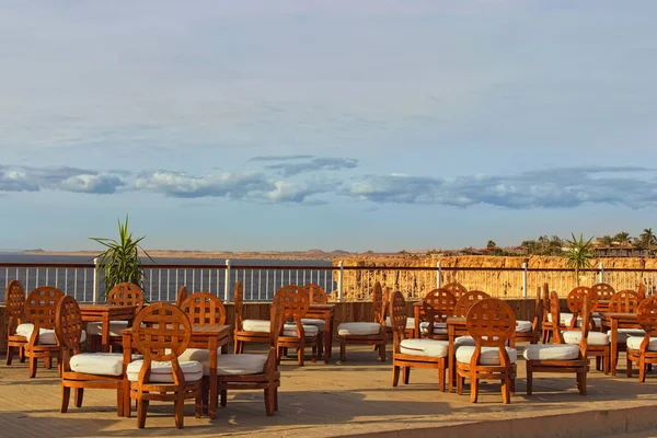 View of empty outdoor cafe in Egypt. Picturesque view of Red Sea coast. Stunning landscape during sunny day. Summer vacation concept. Sharm El Sheikh, Egypt.