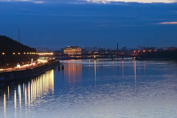 Kiev, Ucrânia - 17 de março de 2019: Paisagem noturna da cidade. Ponte pedonal iluminada sobre o rio Dnipro, silhuetas de edifícios ao fundo — Fotografia de Stock