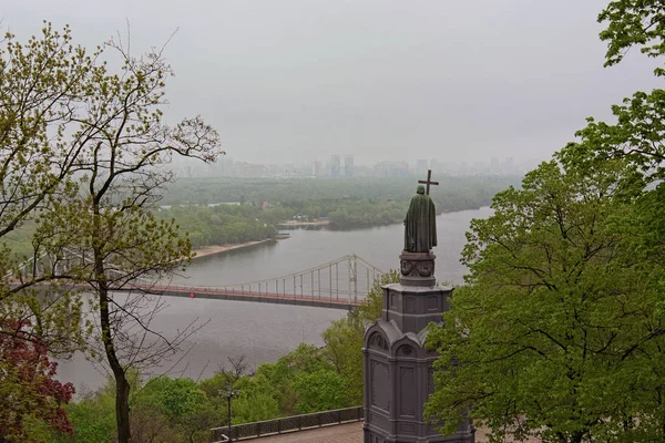 Vista paisagem do rio Dnipro com a ponte pedonal e famoso Monumento de Vladimir O Grande durante a manhã nebulosa primavera. Saint Vladimir Hill, Kiev, Ucrânia — Fotografia de Stock