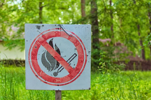 Kein Streichholzfeuer altes Schild. rote Runde mit gekreuztem Streichholz. verschwommener Naturhintergrund. Verbot, ein Feuer anzuzünden. ich mache kein Brandzeichen — Stockfoto