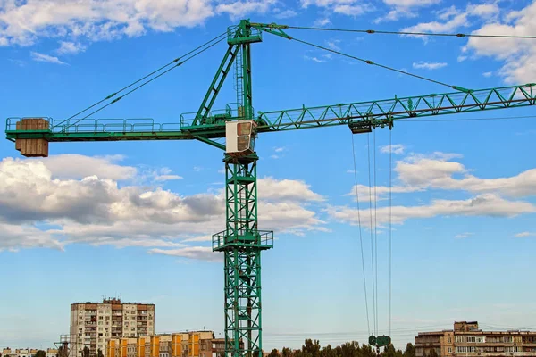 Vista ravvicinata della gru contro il cielo blu con belle nuvole bianche. Gru a torre verde che costruisce il nuovo edificio residenziale. Cantiere, Kiev, Ucraina — Foto Stock