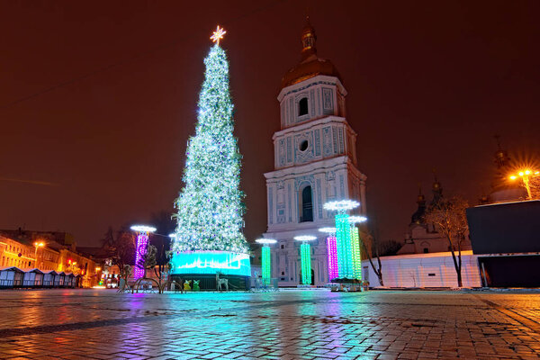 Широкоугольный пейзаж Софийской площади в Киеве, Украина. Потрясающее украшение новогодней елки и киосков Рождественской ярмарки зимним утром. Утренний городской пейзаж без людей
   