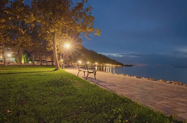 Weitwinkel-Landschaftsaufnahme des Abends am Plattensee. Platanenallee mit beleuchteten Straßenlaternen. Reise- und Tourismuskonzept. balatonfoldvar, ungarisch — Stockfoto