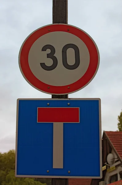 Dos señales de tráfico en el poste contra el cielo nublado representan límite de velocidad y señal de punto muerto. Balatonfoldvar, Hungría. Concepto de señal de tráfico —  Fotos de Stock