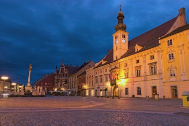 Maribor, Slovenya-24 Eylül 2019: Maribor 'daki Rotovz Town Hall Square' in sabah manzarası. Ortaçağ binaları, canlı sonbahar gökyüzüne karşı. Ünlü turistik mekan ve tatil beldesi