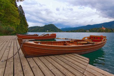 Bled Gölü 'ne (Blejsko jezero) demirlemiş üç ahşap kayıkla verimli sonbahar manzarası. Avrupa 'nın ünlü turistik mekanı ve tatil beldesi. Kan, Slovenya