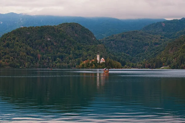 A Bled-tó festői őszi tájképe. Fenséges kilátás nyílik a Szent Mária-templom Nagyboldogasszony kis szigeten szemben a hegység. Bled-tó, Északnyugat-Szlovénia felső-karniolai régiója — Stock Fotó