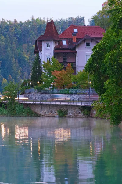 Scénický ranní pohled na starobylý tradiční dům v blízkosti jezera Bled. Ranní mlha na vodní hladině a pád barevné stromy pozadí. Bled Lake, Horní Carniolan regionu severozápadního Slovinska — Stock fotografie