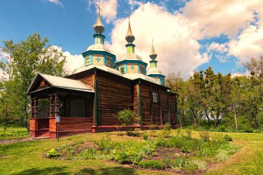 Güneşli bir günde mavi gökyüzüne karşı antik ahşap kilisenin geniş açılı manzarası. Açık Hava Halk Mimari ve Yaşam Müzesi. Antik Ukrayna 'nın tarihi binaları.