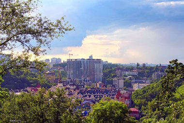 Güneşli bir yaz öğleden sonrasında Kyiv 'in tarihi kısmının panoramik manzarası. Ön planda Vozdvizhenka adlı modern yerleşim yeri bulunuyor. Ağaç Yaprakları Sınırı. Doğal Çerçeve. Kyiv, Ukrayna.
