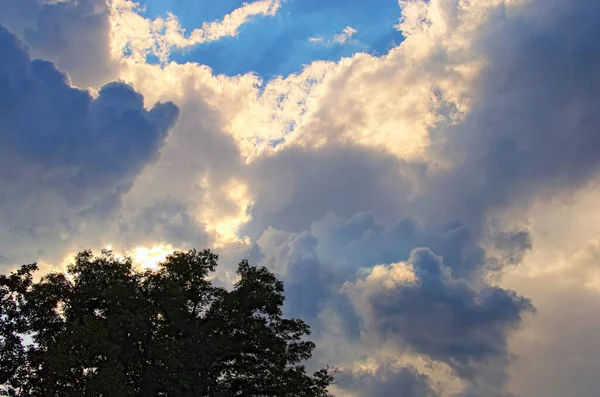 Colorful vibrant sky. Light from heaven. Picturesque view of sky with clouds. They are backlit by the sun. Blue sky background with clouds. Beautiful sky with cloud before sunset. Abstract background.