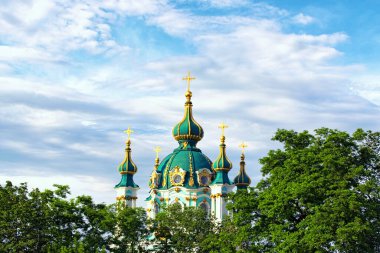 Eski Aziz Andrew Kilisesi 'nin güzel dekore edilmiş kubbesinin yaz manzarası. Bu bir Barok katedrali. Arka planda renkli, canlı bir gökyüzü. Ağaç sınırı terk eder. Kyiv, Ukrayna.