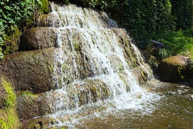 Ukrayna 'nın Bila Tserkva kentindeki Arboretum Alexandria' daki Antik İskenderiye adlı yerin yakınındaki küçük şelalenin resimli manzarası. Manzara ve doğa kavramı. Yaz güneşli bir gün.
