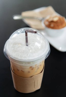 Kapuçino buzlu kahve bir bardak koyu ahşap masa üzerinde arka plan bulanık