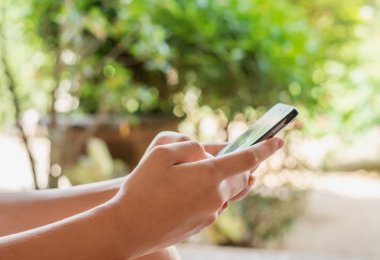 Bağlama ve sosyal ağ kavramı, el genç kadınlar akıllı telefon mobil bokeh doğa arka plan üzerinde kullanma