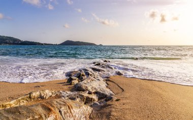 Beyaz kumlu, mavi denizli, mavi gökyüzü ve yaz mevsiminde güneşli beyaz bulutlu sahil.