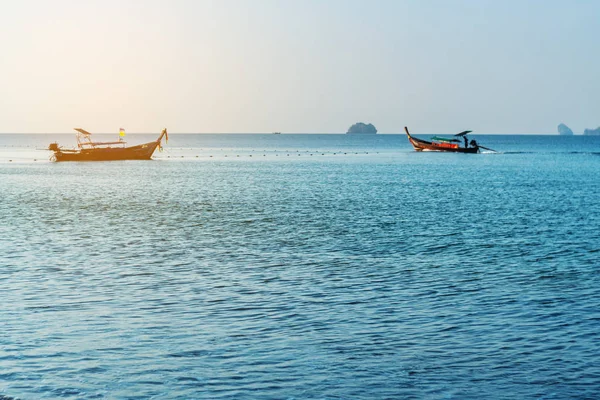 Sabah ışığında balıkçı teknesi ile deniz gündoğumu veya gün batımı
