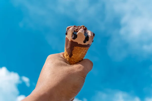 Ruka se zmrzlinou na rozostřené modré obloze přírodní pozadí — Stock fotografie