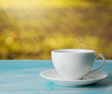 Bir fincan kahve, soyut ışık, altın rengi güneş ışığı.