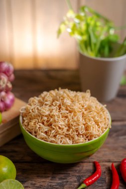 Limonlu, biberli, soğanlı ve ahşap masa üzerindeki sebzeli erişte.