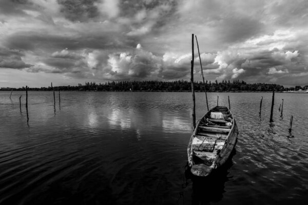 Рыбацкая лодка и водный барьер и река с цветом облака небо шторм в сезон дождей, черно-белый и монохромный стиль