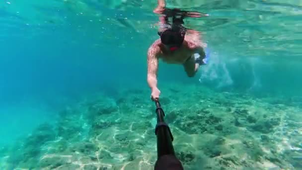 Hombre disparando vídeo bajo el agua sobre sí mismo por su cámara de acción — Vídeo de stock
